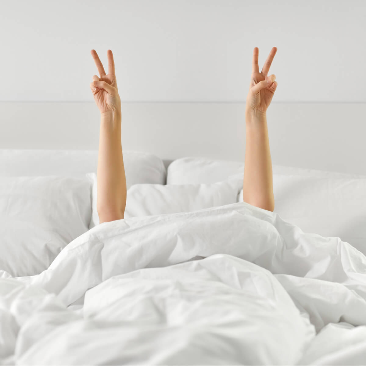 Beige ottoman bed partially lifted to show twin storage compartments at Ideal Beds Chesterfield.