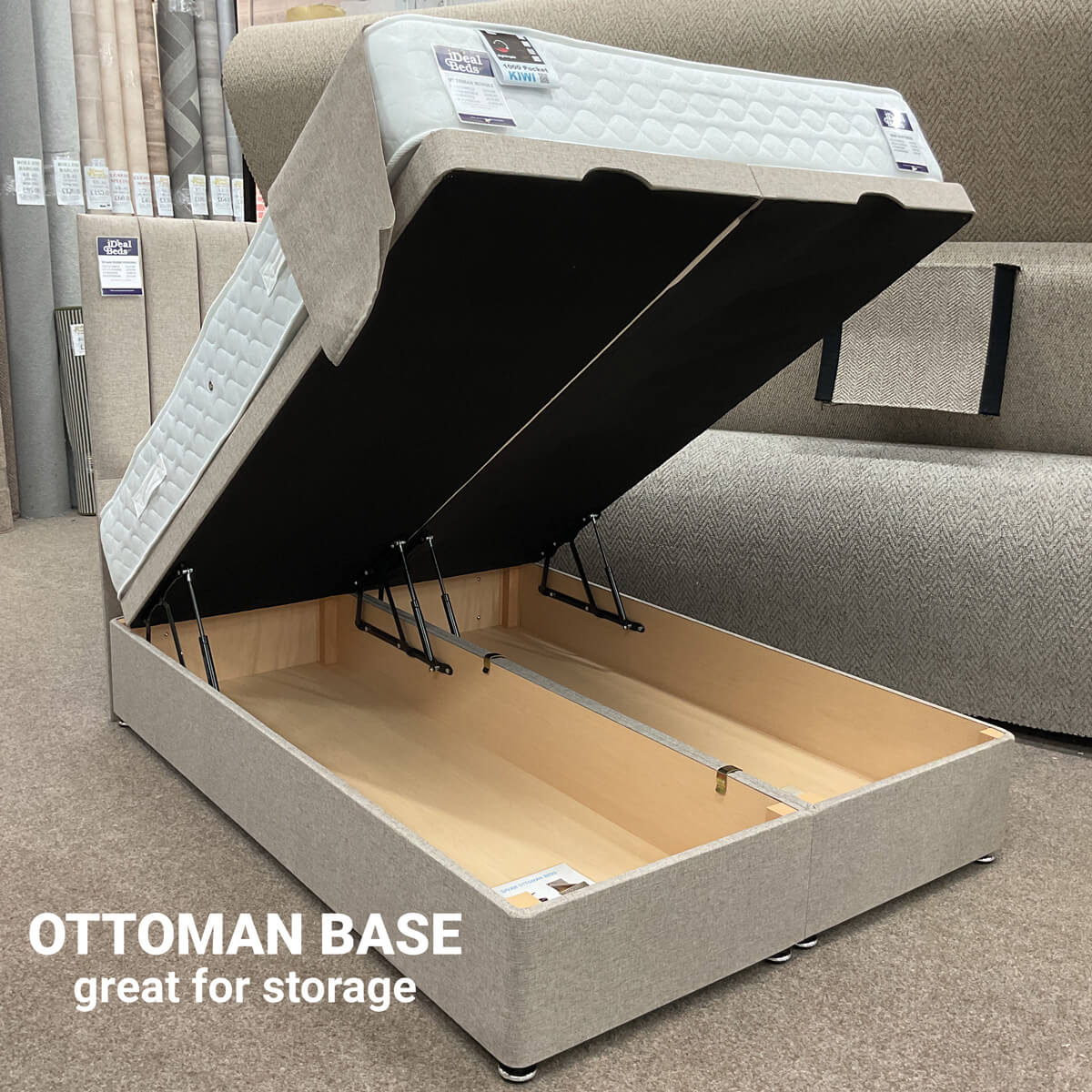 Ottoman bed base in beige fabric, shown fully open with gas-lift mechanism and spacious under-bed storage.